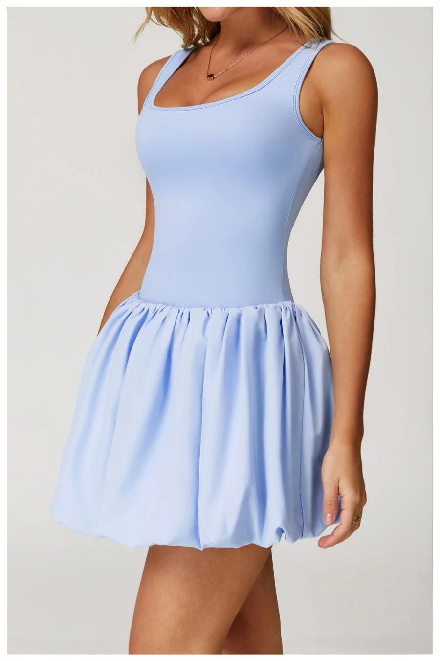 Side view of sports dress highlighting waist-cinching pleated detail and A-line flounce hem