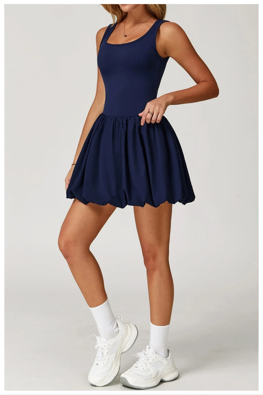 Side view of sports dress highlighting waist-cinching pleated detail and A-line flounce hem