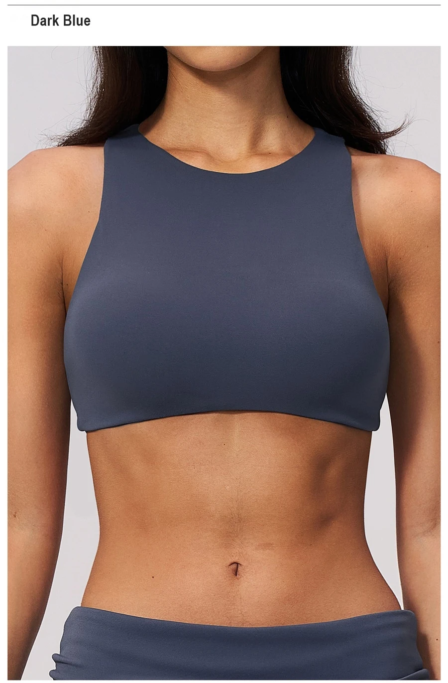 Woman wearing high impact backless sports bra during yoga and gym training-dark blue