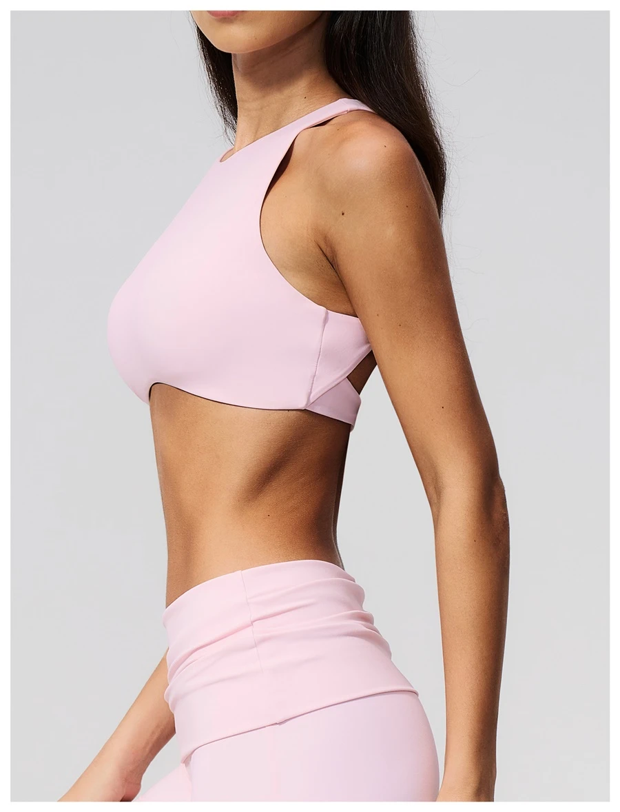 Woman wearing high impact backless sports bra during yoga and gym training-pink side view