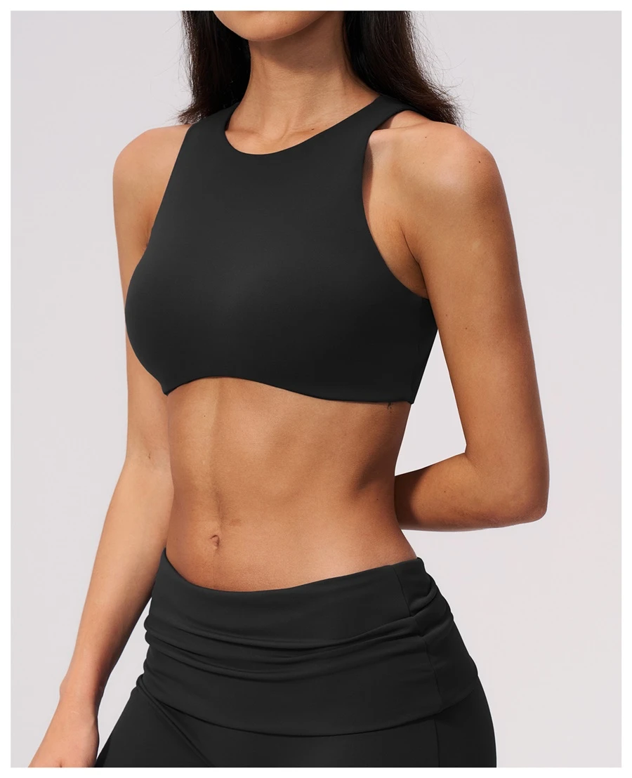 Woman wearing high impact backless sports bra during yoga and gym training-black
