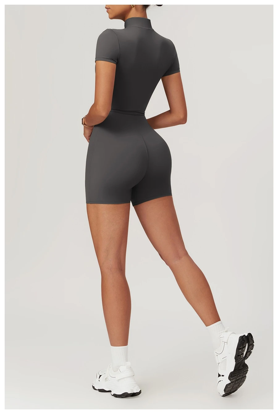 Back view of women's short sleeve zip-up bodysuit showing seamless fit and curve-hugging design